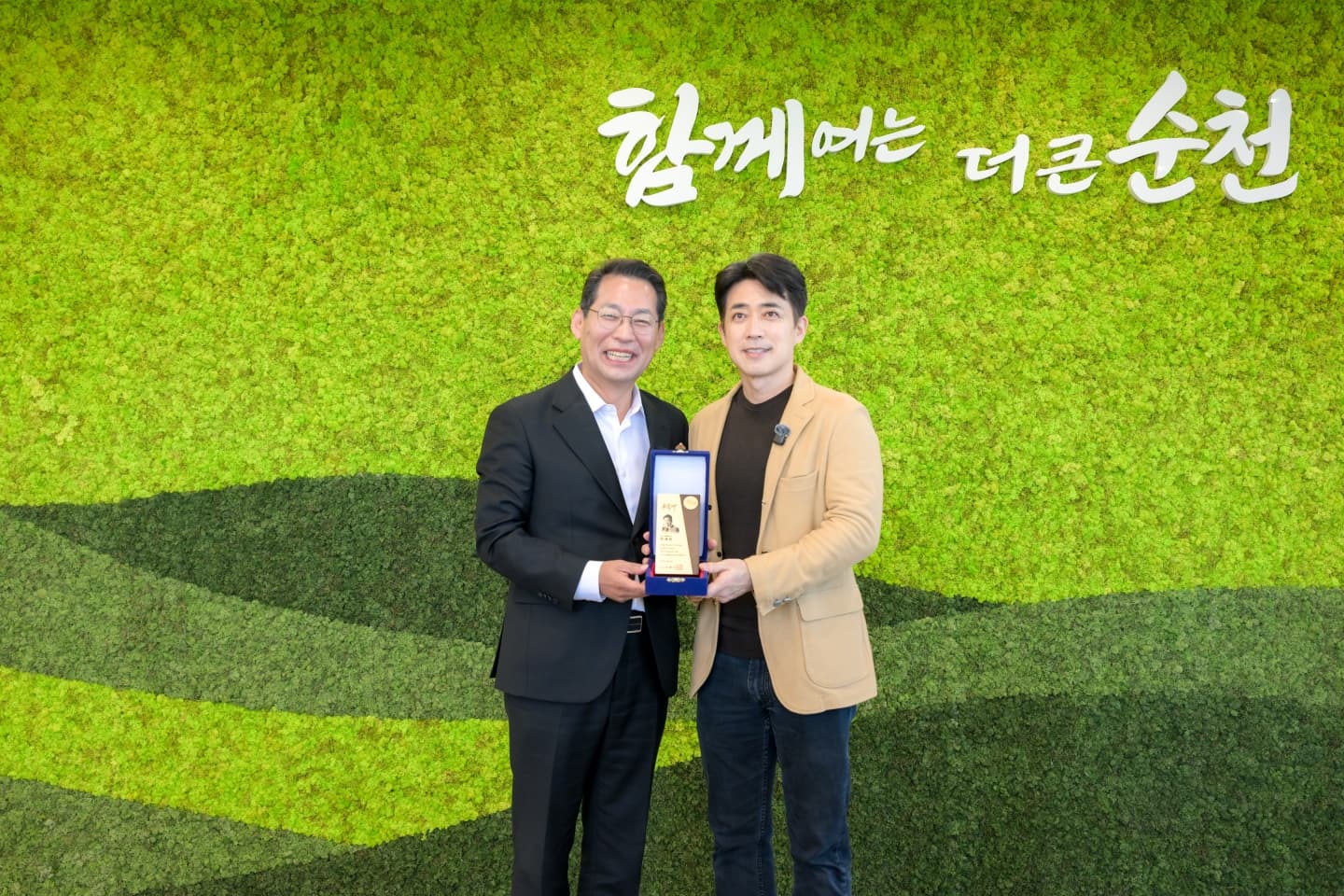 손훈모 순천시장과 명예홍보대사로 위촉된 배우 최재원이 위촉패를 들고 기념촬영하는 모습