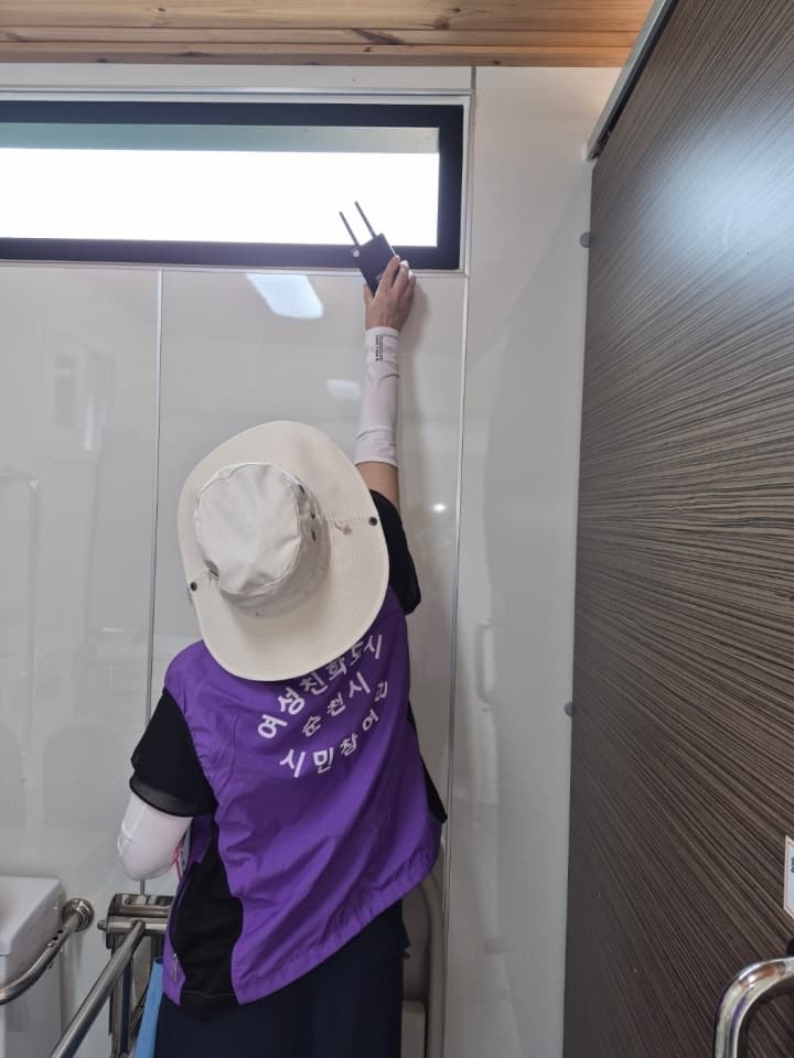여성친화도시 시민참여단원이 공원 화장실에서 불법카메라 탐지기로 점검하는 모습