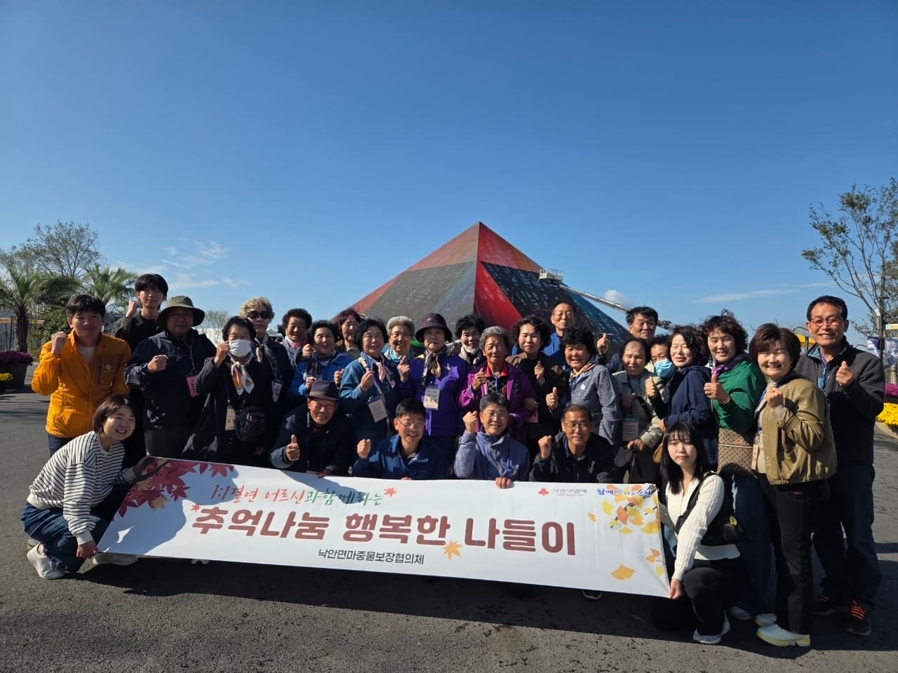 낙안면 마중물보장협의체와 어르신들이 나들이 현수막을 들고 여수에서 기념촬영하는 모습