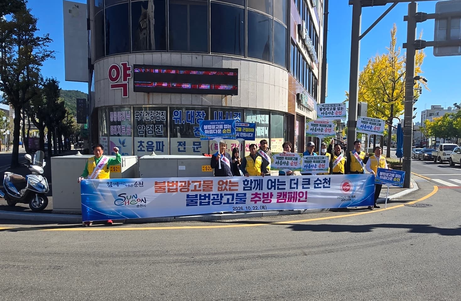 도로변에서 불법광고물 추방 캠페인 현수막과 피켓을 든 참가자들